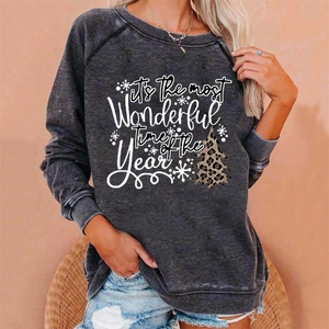 Close-up of vintage dark grey sweatshirt featuring leopard print Christmas tree design