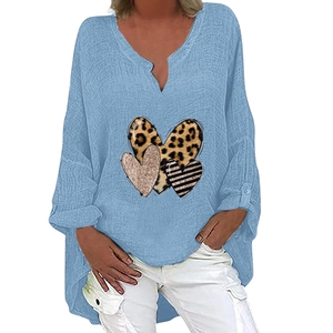 Detail of light blue V-neck linen shirt with heart-shaped leopard and pink prints