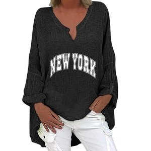 Detail of black V-neck top with New York print and asymmetrical high-low hem design
