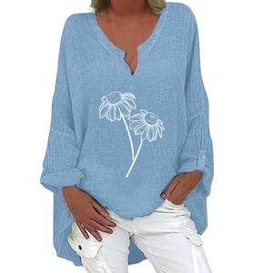 Detail showing light blue V-neck linen shirt with white daisy print and high-low hem
