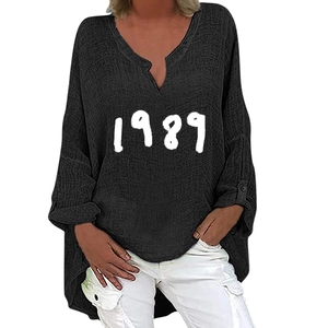 Detail view of black V-neck long sleeve top featuring white 1989 printed graphic design