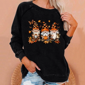 Close-up of autumn gnomes and maple leaves print on a black long sleeve sweatshirt