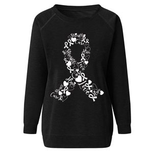 Detail of the pink breast cancer awareness ribbon print on a black crewneck sweatshirt