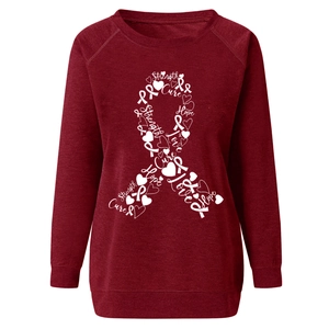 Detailed close-up of pink ribbon lettering print on a burgundy oversized sweatshirt