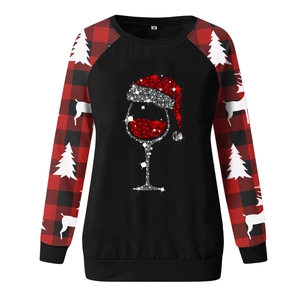 Detail of Christmas sweatshirt featuring red wine glass print and buffalo plaid sleeves