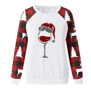 Detail of glitter wine glass print and buffalo plaid sleeves on Christmas sweatshirt