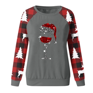 Detail of Christmas sweatshirt featuring raglan plaid sleeves and wine glass graphic