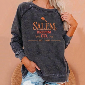 Close-up of vintage Salem Broom Co. orange print on charcoal grey washed sweatshirt