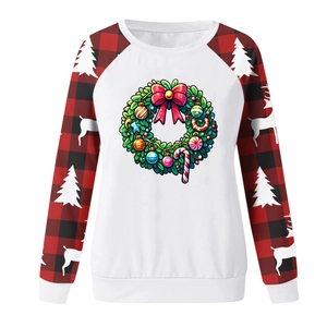 Close-up of a Christmas sweatshirt with festive wreath print and plaid raglan sleeves