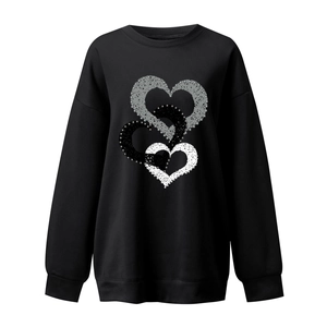 Close-up of heart print with textured silver pearls on a black crewneck sweatshirt