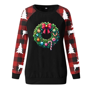 Close-up of Christmas wreath print and red buffalo plaid sleeves on sweatshirt