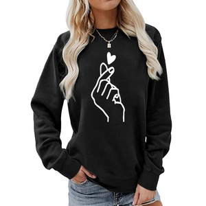 Women's black crewneck sweatshirt with white finger heart print on studio background