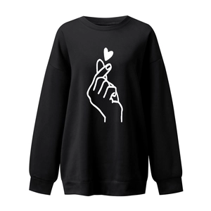 Detail of black crewneck sweatshirt with white heart gesture print and ribbed cuffs