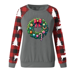 Detail view of Christmas wreath print and red black plaid sleeves on sweatshirt