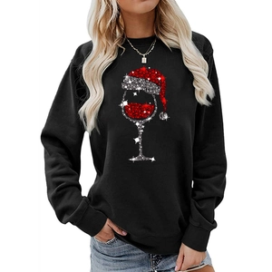 Close-up of festive wine glass with Christmas hat print on black sweatshirt fabric