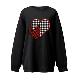 Detail of the buffalo plaid heart print and ribbed cuffs on black sweatshirt