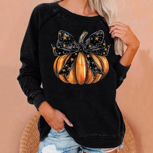 Detail of Halloween pumpkin graphic and bow on black long sleeve crewneck sweatshirt