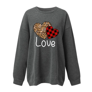 Detail view of heart prints with leopard and buffalo plaid patterns on a gray sweatshirt