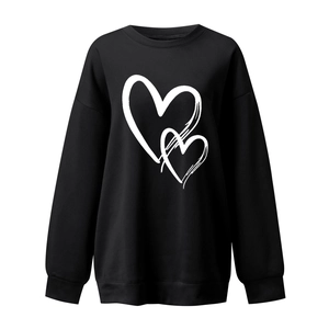 Detail shot of the elastic ribbed cuffs and white heart print on a black crewneck sweatshirt