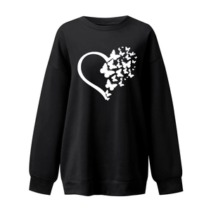 Close-up of white heart and butterfly print on a black long sleeve crewneck sweatshirt
