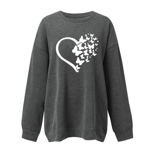 Detail of white butterfly heart print on a dark gray crewneck long sleeve sweatshirt