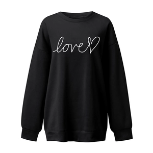 Close-up of black oversized sweatshirt featuring white love text and heart print detail