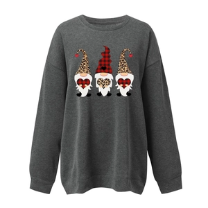 Detail of loose-fit grey sweatshirt featuring three festive cartoon gnomes and buffalo plaid