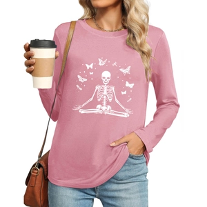 Close-up of pink long-sleeve tee featuring white meditation skeleton and butterfly print