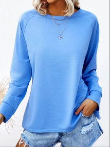 Detail of light blue crew neck sweatshirt featuring raglan sleeves and ribbed cuffs