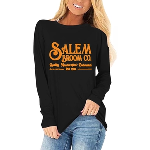 Gros plan sur l'imprimé vintage Salem Broom Co. orange sur ce t-shirt noir d'Halloween