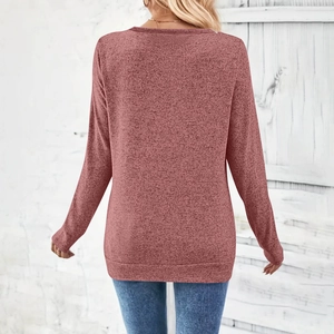 Detail of soft brushed knit texture and ribbed hem on a dusky pink V-neck long sleeve top