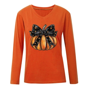 Détail du t-shirt orange à col en V avec imprimé citrouille festive et nœud noir