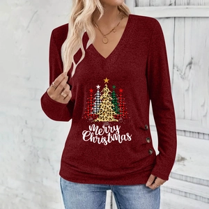 Detail of Christmas tree print and decorative buttons on a burgundy V-neck long sleeve top
