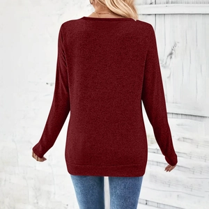 Detail showing the burgundy textured fabric and long sleeves of the elegant V-neck top