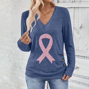 Macro detail of blue V-neck top showing side buttons and pink glitter ribbon print