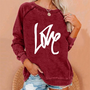 Detail of the white LOVE script printing on a burgundy crewneck sweatshirt for women