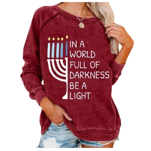 Detail of Menorah print and Be A Light text on a deep red winter sweatshirt