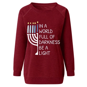 Detail of Hanukkah Menorah print and motivational text on wine red cotton sweatshirt