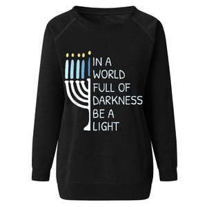 Detail of Menorah print and Be A Light slogan on a black cotton blend sweatshirt