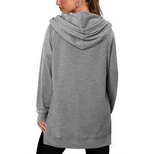 Détail du sweat à capuche gris montrant les manches raglan et l'ourlet fendu sur le côté