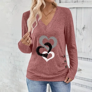 Detail view of heart print pattern and decorative buttons on a V-neck long sleeve top