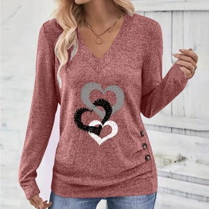 Detail of V-neck long sleeve top with heart print and decorative buttons on the side