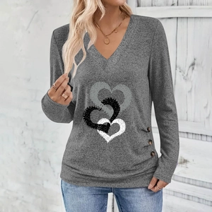 Detail view of heart print and decorative wood buttons on gray V-neck long sleeve top