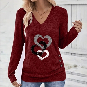 Close-up of heart print pattern and side button details on burgundy V-neck top