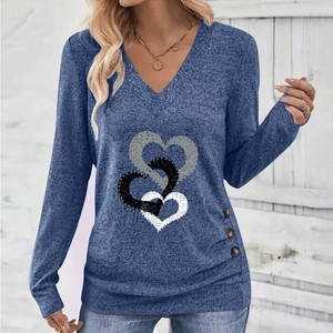 Detail of V-neck top showing interlocking heart print and decorative side buttons
