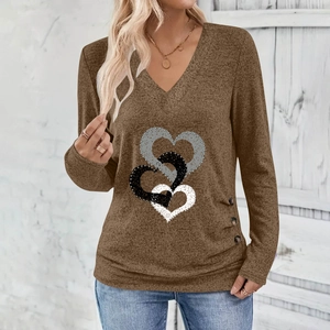 Detail of V-neck top showing coffee brown fabric with heart print and decorative buttons