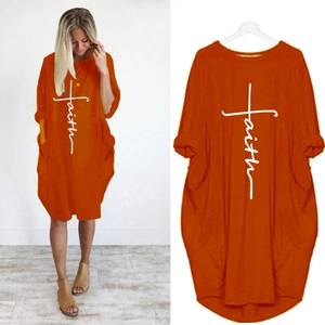 Détail d'une robe orange avec imprimé Faith en croix blanche et grandes poches latérales