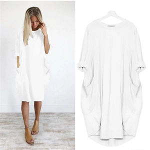 Détail d'une robe oversize blanche en coton avec col rond et grandes poches latérales