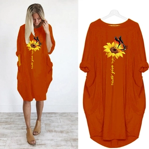 Detail of orange dress showing sunflower butterfly print and side pocket design