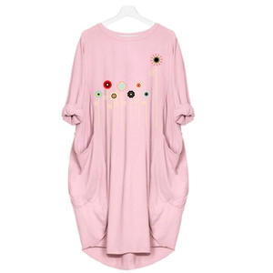Close-up of pink long-sleeved dress with floral print and functional side pockets